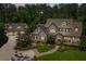 Aerial shot showcasing the home's elegant architecture, manicured lawn, and the convenience of a detached three-car garage at 193 Stonegate Trl, Carrollton, GA 30116