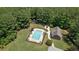 Aerial view of the pool and pool house with lounge chairs surrounded by trees at 193 Stonegate Trl, Carrollton, GA 30116