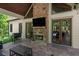 Covered patio featuring a brick fireplace, outdoor kitchen, TV, and wood French doors at 193 Stonegate Trl, Carrollton, GA 30116
