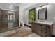 Bathroom featuring a glass shower, dark wood cabinets and a large mirror at 193 Stonegate Trl, Carrollton, GA 30116