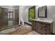 Bathroom with rustic-style wooden cabinets and a glass-enclosed walk-in shower, plus a nice window view at 193 Stonegate Trl, Carrollton, GA 30116