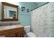 Bathroom with a wood framed mirror and vanity, plus patterned shower curtain at 193 Stonegate Trl, Carrollton, GA 30116