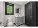 Bathroom featuring a gray vanity, modern sink, and black-trimmed window at 193 Stonegate Trl, Carrollton, GA 30116