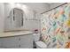 Bathroom with colorful shower curtain, oval mirror, white commode and storage vanity at 193 Stonegate Trl, Carrollton, GA 30116