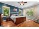 Spacious bedroom featuring hardwood floors, ample natural light from large windows, and stylish blue accent wall at 193 Stonegate Trl, Carrollton, GA 30116