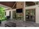 Inviting covered patio featuring a stone fireplace, mounted TV, and comfortable seating, perfect for outdoor gatherings at 193 Stonegate Trl, Carrollton, GA 30116
