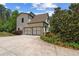 Two car garage with concrete driveway is bordered by flowers and green landscaping at 193 Stonegate Trl, Carrollton, GA 30116