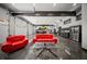 View of the garage featuring car lift, stainless steel refrigerator, epoxy floors and comfortable seating area at 193 Stonegate Trl, Carrollton, GA 30116