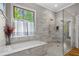 Bathroom featuring marble surround tub and walk-in shower with tile surround and glass door at 193 Stonegate Trl, Carrollton, GA 30116