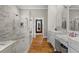 Main bathroom with tiled walk-in shower, dual sink vanities, and hardwood floors at 193 Stonegate Trl, Carrollton, GA 30116