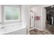 Relaxing bathroom with soaking tub, glass-enclosed shower, and access to a walk-in closet at 210 Kestrel Cir, Covington, GA 30014