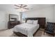 Cozy bedroom featuring a comfortable bed, ceiling fan, and dark wood furnishings at 210 Kestrel Cir, Covington, GA 30014