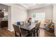 Cozy dining room features modern table, comfortable upholstered chairs, and natural light from the window at 210 Kestrel Cir, Covington, GA 30014