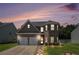 Charming two-story home with a two-car garage, brick facade, manicured lawn, and beautiful twilight sky at 210 Kestrel Cir, Covington, GA 30014