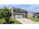 Charming two-story home with a two-car garage, manicured lawn and lush green tree at 210 Kestrel Cir, Covington, GA 30014
