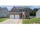 Charming two-story home with a two-car garage, brick facade, manicured lawn and stone pathway at 210 Kestrel Cir, Covington, GA 30014