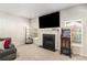 Cozy living room with plush carpeting, fireplace, large TV, and windows offering plenty of natural light at 210 Kestrel Cir, Covington, GA 30014