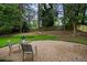 Secluded backyard with mature trees, new fence, and gravel patio at 3408 Chestnut Dr, Doraville, GA 30340