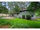 Large backyard with a patio area, lush green grass, and plenty of trees at 3408 Chestnut Dr, Doraville, GA 30340