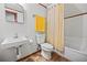 Simple bathroom featuring a toilet, sink, and shower/tub combo with yellow shower curtain and towels at 3408 Chestnut Dr, Atlanta, GA 30340