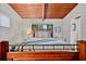 Bedroom features a wood plank ceiling, window and hardwood floors, adding rustic warmth at 3408 Chestnut Dr, Doraville, GA 30340
