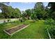 View of Doraville Unity Garden's various garden beds, green grass, and nearby wooded area at 3408 Chestnut Dr, Doraville, GA 30340