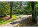View of home with a long driveway, lush landscaping, and mature trees at 3408 Chestnut Dr, Doraville, GA 30340