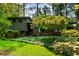 View of home featuring a well-manicured lawn, brick accents, and mature trees at 3408 Chestnut Dr, Doraville, GA 30340