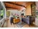 Bright living room with wood-beamed ceilings, a brick fireplace, and large windows showcasing the outdoor view at 3408 Chestnut Dr, Atlanta, GA 30340