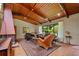 Cozy living room with a vaulted wood ceiling, fireplace, and large windows overlooking the yard at 3408 Chestnut Dr, Doraville, GA 30340