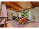 Warm living room features a unique brick fireplace, wood ceiling, and large windows overlooking the backyard at 3408 Chestnut Dr, Doraville, GA 30340