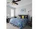 Relaxing bedroom with a ceiling fan, carpet flooring, and a blue leaf-patterned bed spread at 1286 Creekside Se Ter, Smyrna, GA 30082