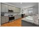 Bright kitchen featuring stainless appliances, granite countertops, mosaic backsplash, and hardwood flooring at 1286 Creekside Se Ter, Smyrna, GA 30082