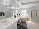 Bright bathroom featuring double sinks, a soaking tub, and an enclosed walk-in shower at 1286 Creekside Se Ter, Smyrna, GA 30082