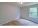 Cozy bedroom featuring a window with tree views and neutral carpet at 1531 Iris Walk, Jonesboro, GA 30238
