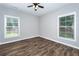 Bright bedroom featuring hardwood floors, ceiling fan and natural light from two windows at 1960 York Dr, Canton, GA 30114