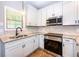 Modern kitchen boasts stainless steel appliances, granite counters and bright white cabinetry at 1960 York Dr, Canton, GA 30114
