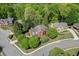 Overhead view of a red brick home with trees, landscaping, and surrounding neighborhood at 3284 Bakers Mill Ct, Dacula, GA 30019