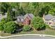 Beautiful aerial view of a traditional brick home with mature trees and manicured landscaping at 3284 Bakers Mill Ct, Dacula, GA 30019