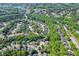 Expansive aerial view showcasing a lush, wooded neighborhood with a lake and winding roads at 3284 Bakers Mill Ct, Dacula, GA 30019
