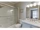 Bathroom with a glass-enclosed shower/tub, white tile, a granite countertop vanity, and modern fixtures at 3284 Bakers Mill Ct, Dacula, GA 30019