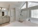 This bathroom features a double vanity, a soaking tub, a standing shower, and triangle windows at 3284 Bakers Mill Ct, Dacula, GA 30019