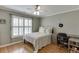 This bedroom features hardwood floors, a ceiling fan, a window, and a desk at 3284 Bakers Mill Ct, Dacula, GA 30019