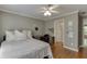 This bedroom features hardwood floors, a ceiling fan, a desk, and access to the hallway at 3284 Bakers Mill Ct, Dacula, GA 30019