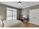 Bedroom with hardwood floors, neutral paint, double-door closet, desk area, and large window with wooden shutters at 3284 Bakers Mill Ct, Dacula, GA 30019