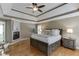 This bedroom features a trey ceiling, hardwood floors, a fireplace, and natural light at 3284 Bakers Mill Ct, Dacula, GA 30019