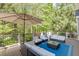 Inviting deck area with outdoor seating, umbrella, and a view of lush trees at 3284 Bakers Mill Ct, Dacula, GA 30019