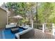 Relaxing outdoor deck area with comfortable seating, an umbrella, and a view of the surrounding greenery at 3284 Bakers Mill Ct, Dacula, GA 30019