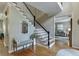 Inviting foyer with hardwood floors, staircase, and a bench with decorative pillows at 3284 Bakers Mill Ct, Dacula, GA 30019