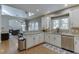 Bright kitchen with white cabinets, granite countertops, stainless steel appliances, and hardwood floors at 3284 Bakers Mill Ct, Dacula, GA 30019